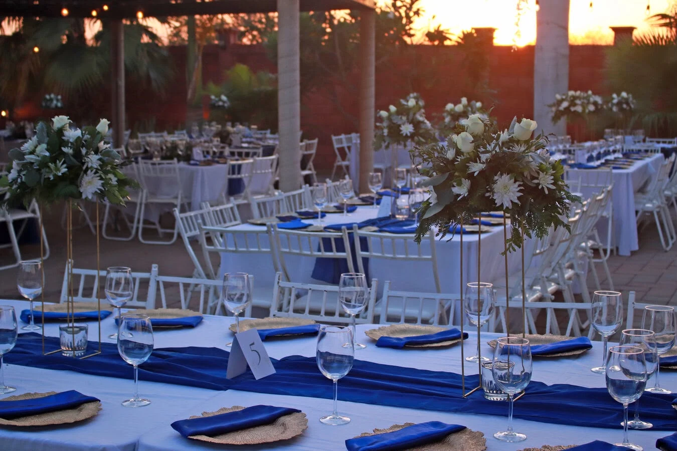 Mesas con flores y detalles azules para una celebración en el campestre